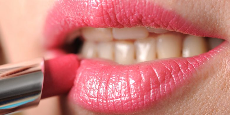 Woman Putting On Lipstick