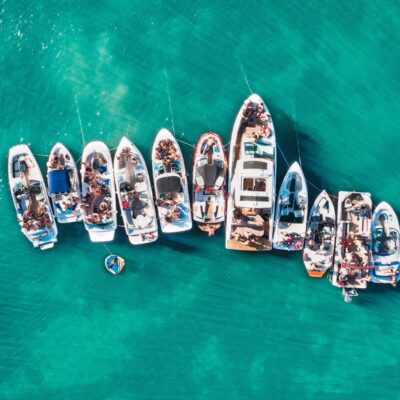 Overhead aerial drone shot of different sized boats docked close to each other near the pier