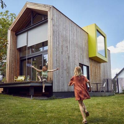 Girl,Running,Towards,Happy,Mother,Sitting,Outside,Tiny,House