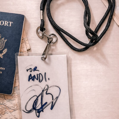 A signed autograph from Anthony Bourdain displayed beside a passport and travel ephemera, symbolizing curiosity, legacy, and a lifelong love of the world.