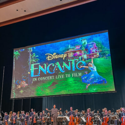 Charlotte Symphony Orchestra finale during Encanto in Concert with conductor and full orchestra on stage at Belk Theater.