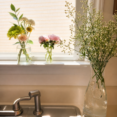 Bright, clean kitchen sink area with fresh flowers by the window, representing a pest-free and well-maintained home.